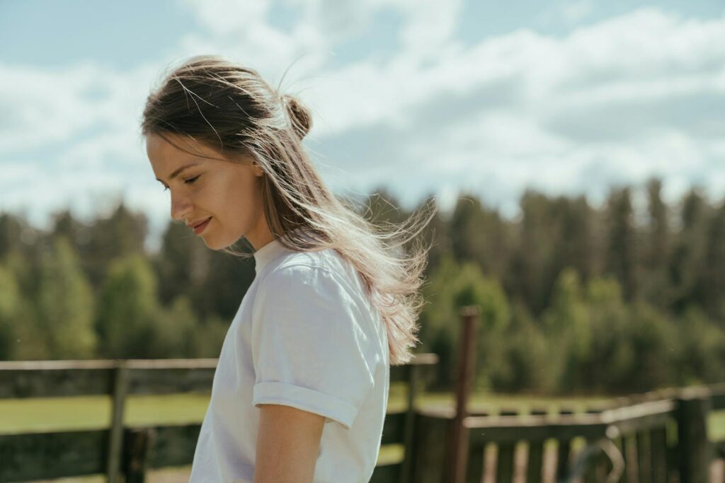 A woman enjoying a serene moment in the countryside on a sunny day.